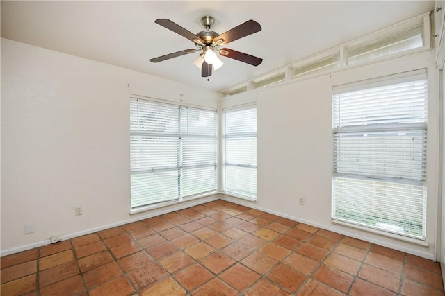 tiled spare room with lofted ceiling, ceiling fan, and baseboards