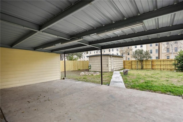 view of patio / terrace with an outbuilding, a fenced backyard, and a shed