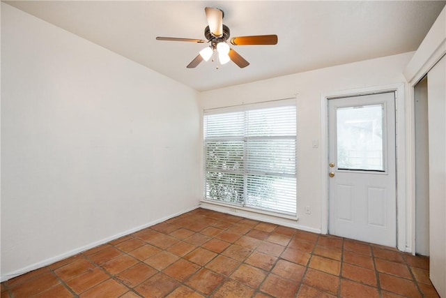 unfurnished room featuring ceiling fan and baseboards