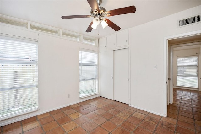 unfurnished bedroom with a closet, visible vents, and ceiling fan