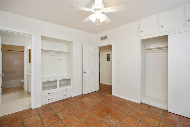 unfurnished bedroom with connected bathroom, visible vents, baseboards, a ceiling fan, and a closet