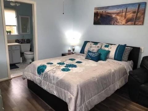 bedroom featuring ensuite bathroom and wood finished floors