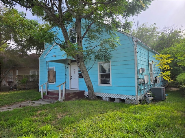 view of front of house featuring central air condition unit and a front yard