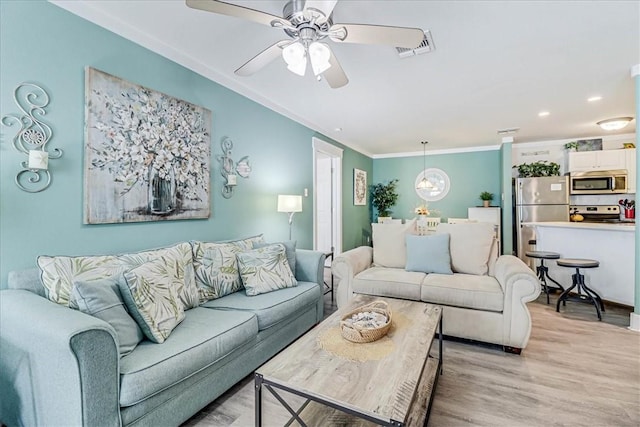 living room featuring ornamental molding, ceiling fan, and light hardwood / wood-style floors