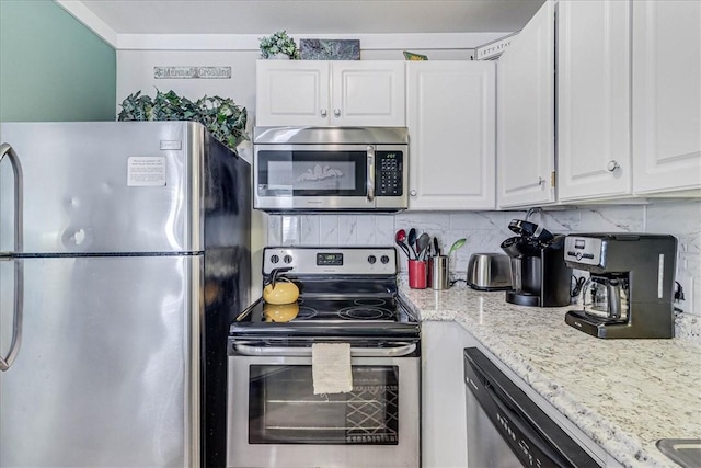 kitchen with stainless steel appliances, light stone countertops, white cabinets, and backsplash