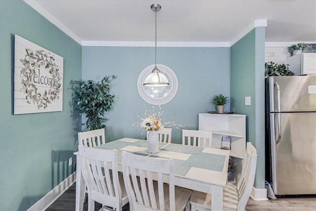 dining room with hardwood / wood-style flooring and ornamental molding