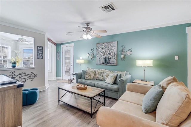 living room featuring hardwood / wood-style flooring, ceiling fan, and ornamental molding