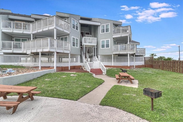 view of home's community with a patio and a lawn