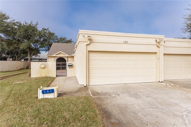 view of front facade featuring stucco siding, a gate, fence, a garage, and driveway