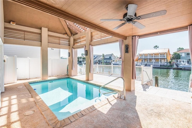 view of pool with a patio, ceiling fan, and a water view