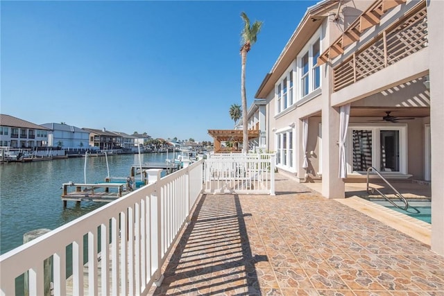 exterior space with a water view, a dock, and ceiling fan