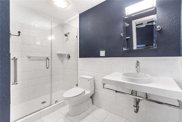 bathroom featuring toilet, an enclosed shower, sink, and tile walls