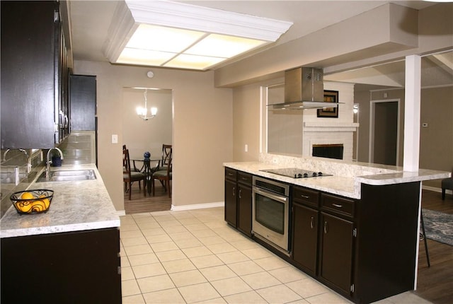 kitchen featuring sink, range hood, oven, a kitchen bar, and black electric stovetop