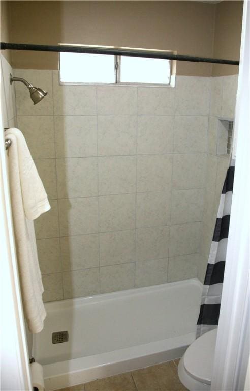 bathroom featuring curtained shower, tile patterned flooring, and toilet