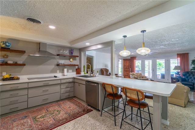 kitchen featuring black electric stovetop, dishwasher, sink, a breakfast bar area, and wall chimney range hood