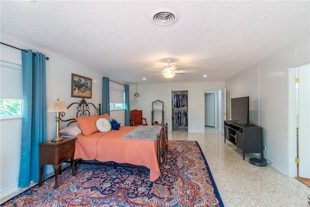 bedroom with a textured ceiling, ceiling fan, crown molding, and a closet