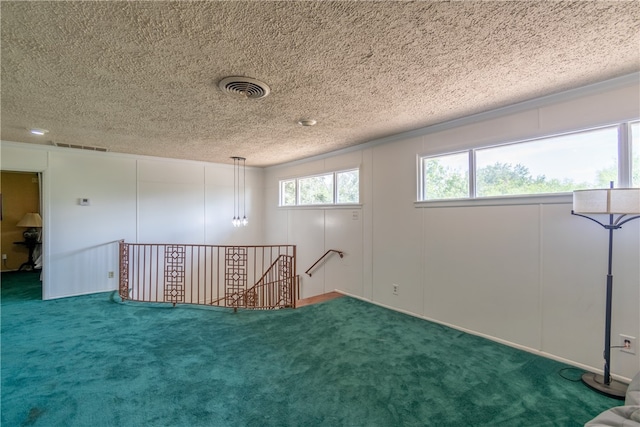 interior space with a textured ceiling and carpet flooring