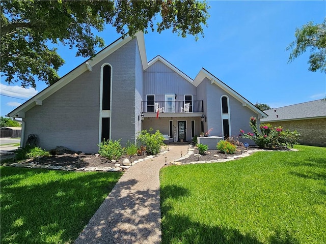 view of front of home with a balcony and a front lawn