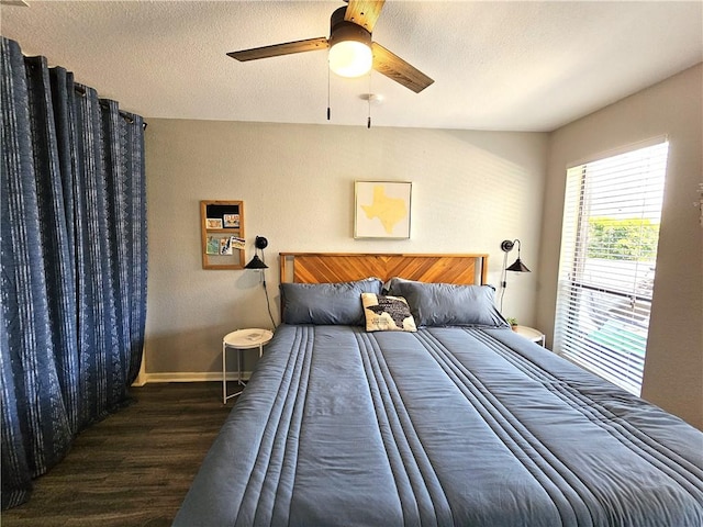 bedroom with a ceiling fan, a textured ceiling, baseboards, and wood finished floors