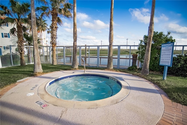 view of pool with a water view and a hot tub