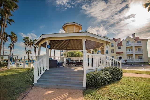 wooden terrace featuring a gazebo and a lawn