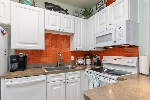 kitchen with white appliances, white cabinetry, and sink