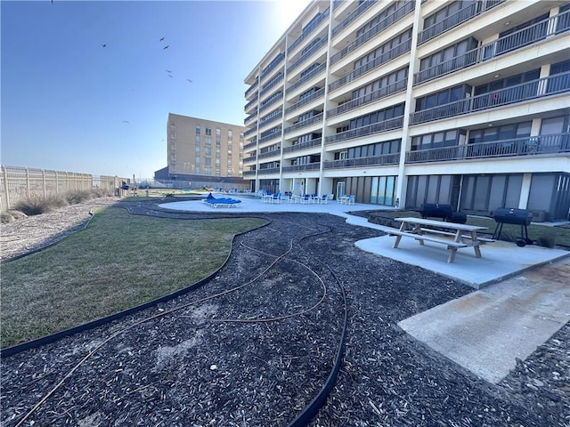 view of community with a patio, a pool, and fence