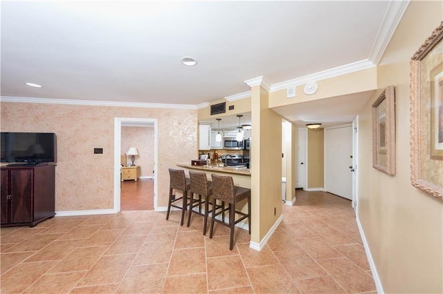 kitchen with baseboards, ornamental molding, light tile patterned floors, a kitchen breakfast bar, and stainless steel appliances