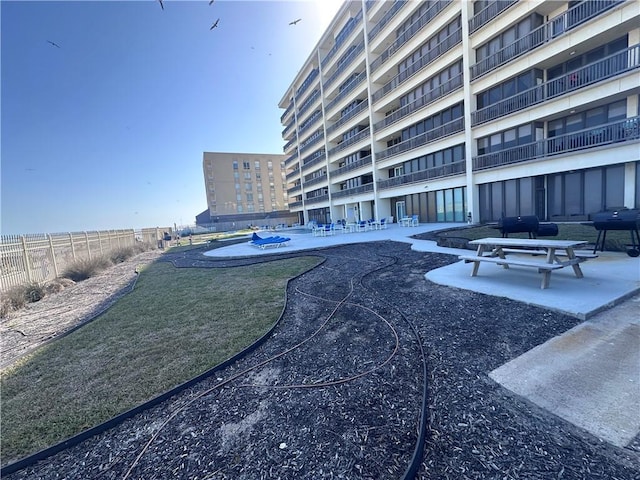 view of community featuring fence and a patio area