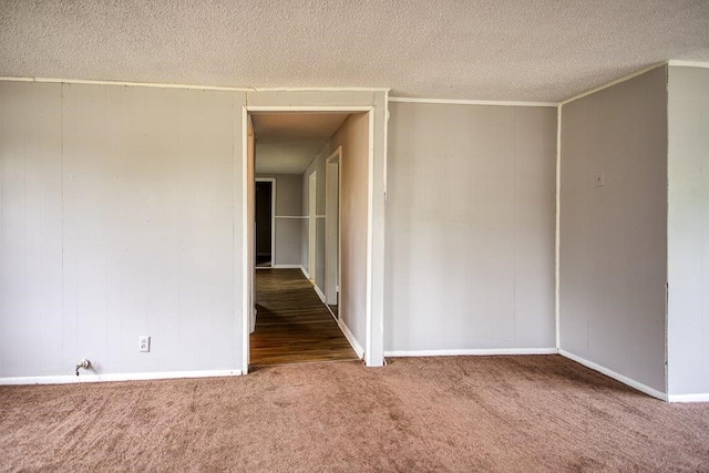 carpeted spare room featuring a textured ceiling and crown molding