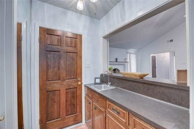 4621 Weiskopf, Corpus Christi, TX 78413 - kitchen featuring dark countertops, lofted ceiling, and brown cabinets