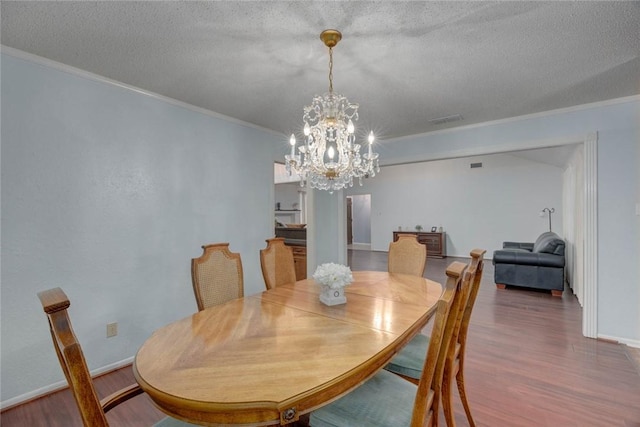 4621 Weiskopf, Corpus Christi, TX 78413 - dining space featuring ornamental molding, wood finished floors, a chandelier, and a textured ceiling