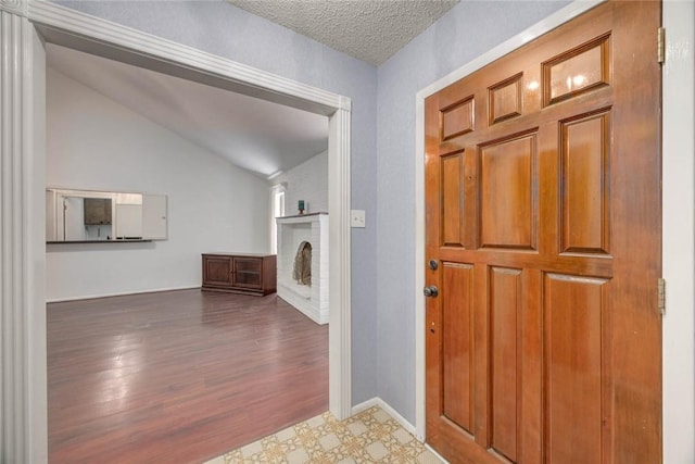 4621 Weiskopf, Corpus Christi, TX 78413 - foyer featuring vaulted ceiling, a brick fireplace, and wood finished floors