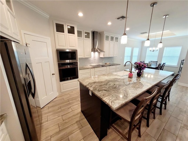 6721 Sharks Ct, Corpus Christi, TX 78414 - kitchen featuring oven, wall chimney exhaust hood, stainless steel fridge, a sink, and black electric cooktop