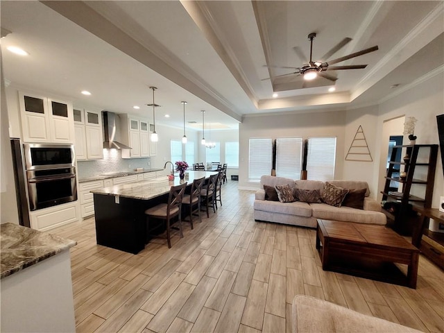 6721 Sharks Ct, Corpus Christi, TX 78414 - living area featuring ornamental molding, light wood-style floors, ceiling fan, a tray ceiling, and recessed lighting