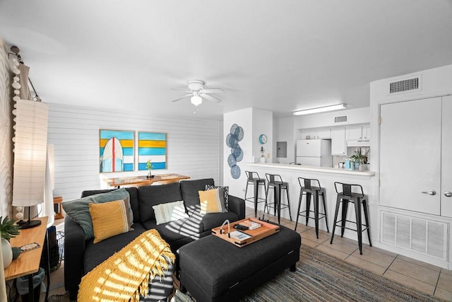 tiled living area featuring a ceiling fan and visible vents