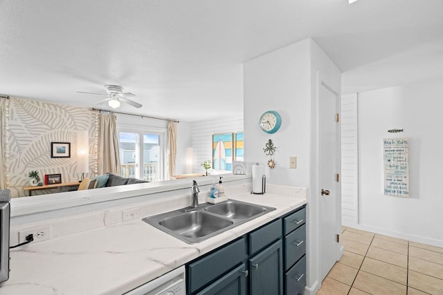 kitchen with light tile patterned flooring, a sink, a ceiling fan, baseboards, and wallpapered walls