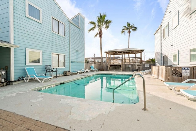 community pool featuring a patio and fence