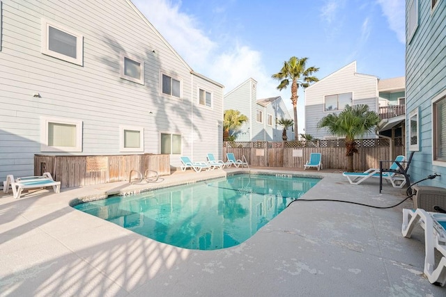 community pool featuring a patio and fence