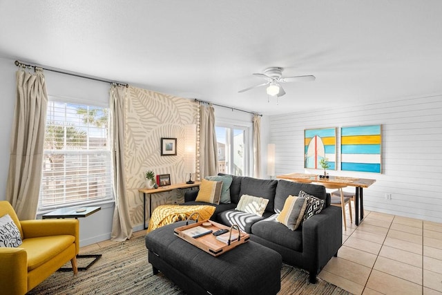 living area featuring visible vents, light tile patterned flooring, a wealth of natural light, and a ceiling fan