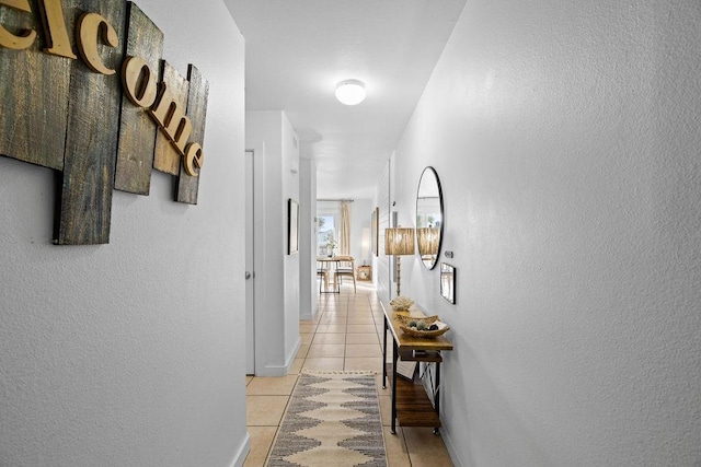 hall with baseboards and light tile patterned flooring