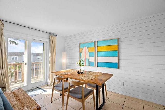 dining room with wood walls and light tile patterned floors