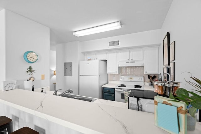 kitchen with white appliances, visible vents, a sink, under cabinet range hood, and backsplash