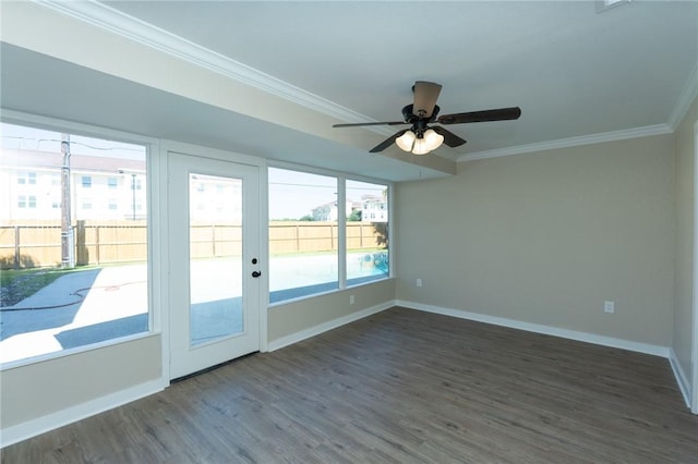 interior space with ornamental molding, a ceiling fan, wood finished floors, and baseboards