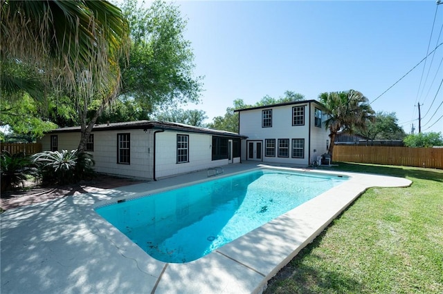 view of swimming pool featuring fence, a yard, a patio area, and a fenced in pool