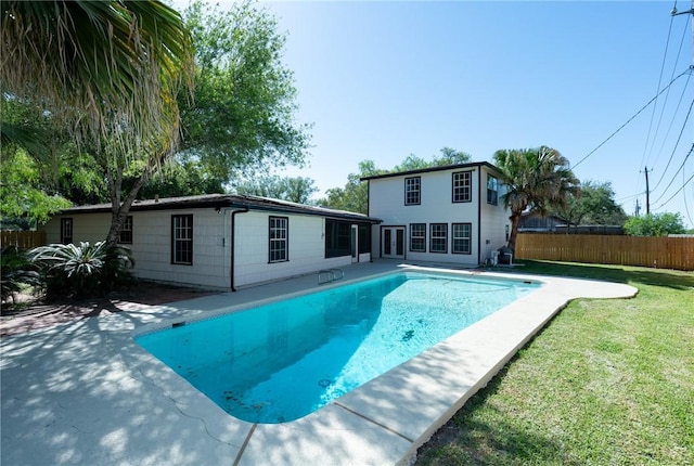 view of swimming pool featuring fence, a lawn, a patio area, and a fenced in pool