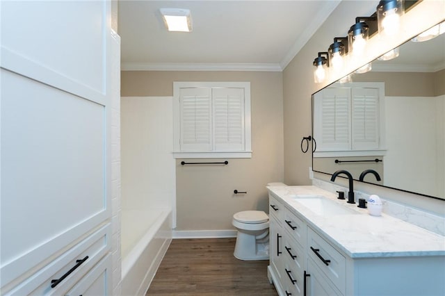 full bathroom featuring vanity, a washtub, crown molding, toilet, and wood finished floors