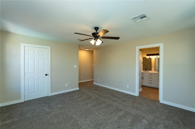 unfurnished bedroom with ensuite bathroom, visible vents, carpet floors, and baseboards