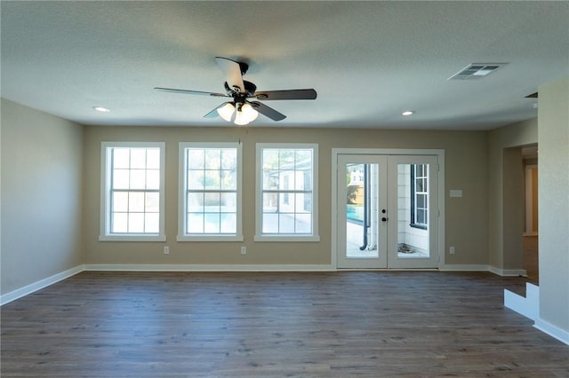 spare room featuring dark wood-style flooring, visible vents, french doors, and baseboards