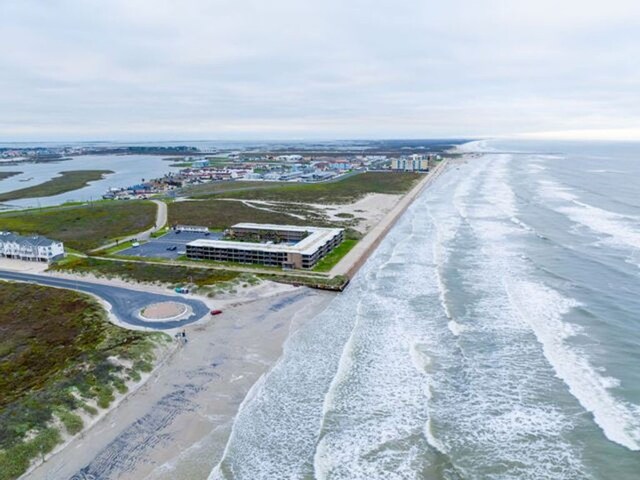 bird's eye view featuring a water view and a beach view